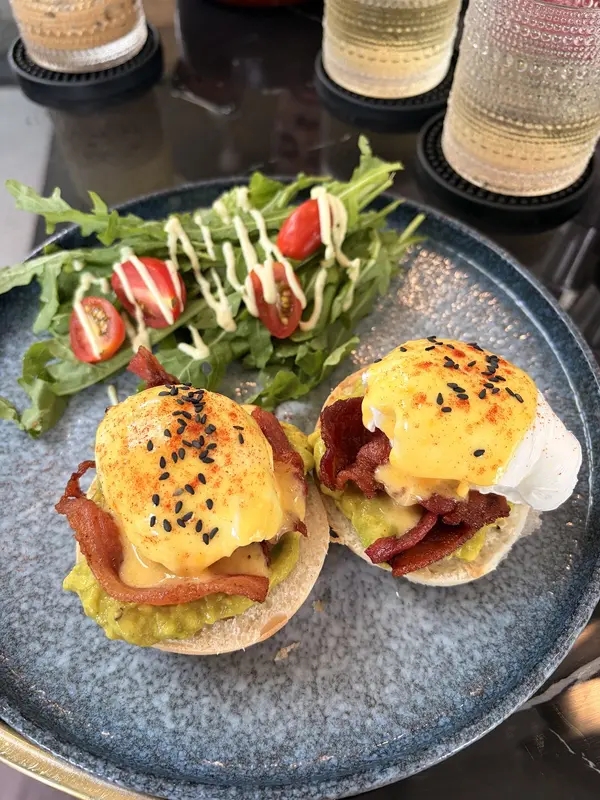 Avocado eggs Benedict with bacon and rocket