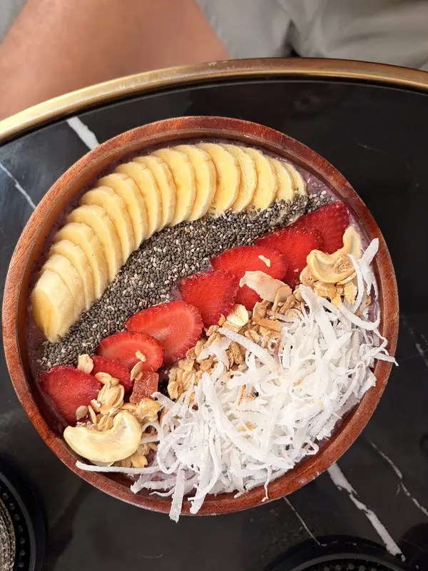 A smoothie bowl with banana, strawberry, chia, coconut and cashews